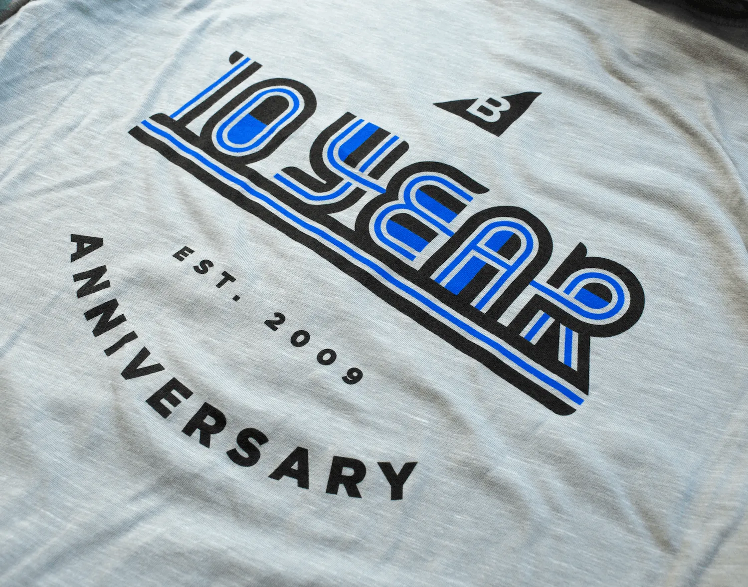 Heather grey t-shirt printed with the 10 Year Anniversary, Est. 2009 graphic