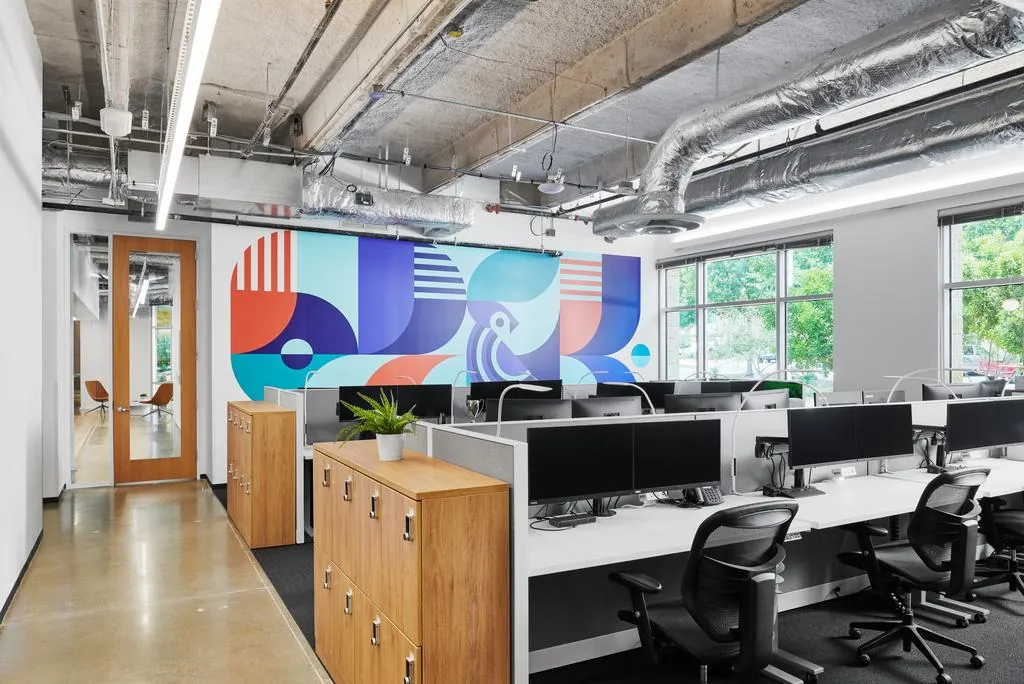 The finished mural spanning an office wall above rows of desks
